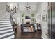 Bright living room with high ceilings, stone fireplace, dark floors, and staircase to upper level at 6065 Ashbury Ln, Cumming, GA 30028