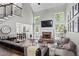 Bright living room boasts fireplace, high ceilings, large windows, dark floors, with adjacent dining area at 6065 Ashbury Ln, Cumming, GA 30028