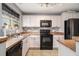 Well-lit kitchen featuring white cabinets, modern appliances, and stylish backsplash at 161 Brasch Park Dr, Grantville, GA 30220