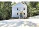 Charming three-story home boasts a welcoming entrance, blue door, and is set amongst lush trees at 2125 Clay Rd, Austell, GA 30106