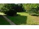 Green backyard featuring a thick canopy of trees providing shade and partial views of the house's siding at 330 Christian Woods Dr, Conyers, GA 30013