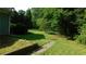 Green backyard featuring lush greenery and partial views of the house's siding at 330 Christian Woods Dr, Conyers, GA 30013