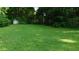 Expansive backyard with lush green grass, mature trees, and storage shed for outdoor living at 330 Christian Woods Dr, Conyers, GA 30013