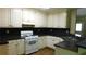 A kitchen featuring white cabinets, black counters, and stainless steel sink at 330 Christian Woods Dr, Conyers, GA 30013