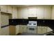 A kitchen featuring white cabinets, a white range, and black counters at 330 Christian Woods Dr, Conyers, GA 30013
