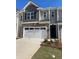 Charming townhome showcasing a two-car garage, stone accents, and neutral gray siding at 1404 Gray Branch Dr, Lawrenceville, GA 30045