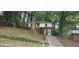 Two-story home with brick and siding exterior and a long driveway surrounded by mature trees at 2980 Wanda Sw Cir, Atlanta, GA 30315