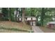 Two-story home with brick and siding exterior and a long driveway surrounded by mature trees at 2980 Wanda Sw Cir, Atlanta, GA 30315