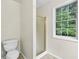 A toilet and shower sit below a window in this efficiently designed bathroom at 405 Mount Vernon Ct, Woodstock, GA 30189