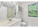 Clean bathroom with a modern vanity, toilet, shower, and a bright window view at 405 Mount Vernon Ct, Woodstock, GA 30189