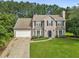 Charming two-story home features a manicured lawn, attached garage, and classic architectural details at 405 Mount Vernon Ct, Woodstock, GA 30189