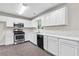 Bright kitchen features white cabinets, stainless steel appliances, and marble countertops at 405 Mount Vernon Ct, Woodstock, GA 30189
