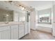 Bright bathroom featuring tile flooring, double vanity, and large soaking tub at 6043 China Rose Lane, Johns Creek, GA 30097