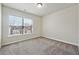 This bedroom offers neutral carpeting, a window and plain white walls at 6043 China Rose Lane, Johns Creek, GA 30097