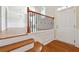 Bright foyer with hardwood floors, stairs with wood and iron railing, and white door at 6043 China Rose Lane, Johns Creek, GA 30097