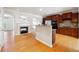 Open layout kitchen with dark wood cabinetry, granite countertops, stainless steel appliances, and hardwood floors at 6043 China Rose Lane, Johns Creek, GA 30097