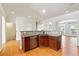 Open kitchen island with granite countertop and stainless steel dishwasher with hardwood flooring at 6043 China Rose Lane, Johns Creek, GA 30097