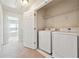 Convenient laundry room featuring a washer, a dryer and storage shelving at 6043 China Rose Lane, Johns Creek, GA 30097