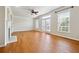 Bright living room boasts hardwood floors, large windows, a fireplace, and a ceiling fan at 6043 China Rose Lane, Johns Creek, GA 30097