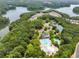 Aerial view of a neighborhood community highlighting the swimming pool, tennis courts, clubhouse, and surrounding trees at 113 Stargaze Rdg, Canton, GA 30114