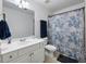 Well-lit bathroom with a single sink vanity, toilet, and a shower/tub combination with a blue patterned curtain at 113 Stargaze Rdg, Canton, GA 30114