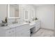 Elegant bathroom featuring dual sinks with backlit mirrors, marble countertops and white cabinetry at 113 Stargaze Rdg, Canton, GA 30114