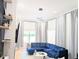 Bright living room features a stylish blue velvet sofa, hardwood floors, and modern décor, creating a cozy atmosphere at 123 Dahlgren St, Atlanta, GA 30317