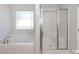 Bright bathroom featuring a soaking tub, separate glass-enclosed shower, and a window at 251 Eason St, Bowdon, GA 30108