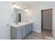 Bathroom featuring double sink vanity with gray cabinets, tile floors and modern lighting at 251 Eason St, Bowdon, GA 30108