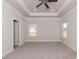 Spacious bedroom with carpet flooring, windows, ceiling fan, and tray ceiling at 251 Eason St, Bowdon, GA 30108