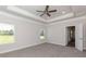 Serene main bedroom with plush carpet, tray ceiling, ceiling fan, and abundant natural light at 251 Eason St, Bowdon, GA 30108