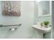 Stylish bathroom featuring a pedestal sink, modern fixtures, decorative mirror, and neutral wall decor at 2063 Willow Chase Ct, Tucker, GA 30084