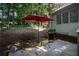 Backyard patio with red umbrella and grill on a beautiful wooded lot at 2063 Willow Chase Ct, Tucker, GA 30084
