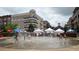 Children playing in the splash pad with jets of water shooting up in a lively community space at 2285 Park Walke Dr, Alpharetta, GA 30009