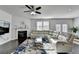 Bright living room featuring a comfortable sofa, a fireplace, and large windows at 4825 Odum View Ln, Cumming, GA 30040