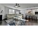 Open-concept living room with a large sofa, a fireplace, and a granite countertop island with bar stools at 4825 Odum View Ln, Cumming, GA 30040