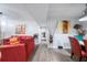 Spacious living room with gray flooring features a red couch and entryway into the hallway at 6487 Northridge Way, Morrow, GA 30260