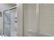 Bathroom with white tile shower, glass door, and white louvered closet doors at 840 United Ave # 113, Atlanta, GA 30312