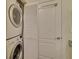 Laundry room with stackable washer and dryer, white door and storage at 840 United Ave # 113, Atlanta, GA 30312