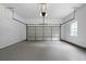 Clean, empty garage with a white door, gray floor, and a bright overhead light at 1460 Bakers Bridge Rd, Douglasville, GA 30134