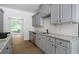 Kitchen features granite counters, gray cabinetry, subway tile backsplash, and stainless appliances at 1460 Bakers Bridge Rd, Douglasville, GA 30134