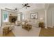 Bright living room features neutral decor, fireplace, ceiling fans, and wood floors at 1460 Bakers Bridge Rd, Douglasville, GA 30134
