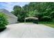 Large concrete area with a carport and a garage door visible near the house at 1460 Bakers Bridge Rd, Douglasville, GA 30134