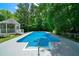 An in-ground pool offers the perfect place to cool off and relax, framed by lush trees at 1460 Bakers Bridge Rd, Douglasville, GA 30134
