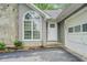 Home front featuring a white front door, arched window, and a stone accent wall and attached garage at 2690 Ross Rd, Snellville, GA 30039