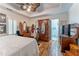 Spacious bedroom with hardwood floors, large bed, ceiling fan, and armoire with adjacent bathroom at 3745 Meeting St, Duluth, GA 30096