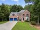 Traditional brick home with blue garage doors, a well-manicured lawn, and mature trees at 41 Wexford Nw Cir, Cartersville, GA 30121