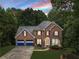 Beautifully landscaped two-story brick home with blue garage doors at 41 Wexford Nw Cir, Cartersville, GA 30121