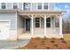 Inviting covered front porch with brick accents, white columns, and a stylish entrance at 109 Laurelwood Ln, Dallas, GA 30157