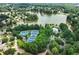 Stunning aerial view of a community with lake, tennis courts, and pool surrounded by lush greenery and mature trees at 1680 Laleiah Dr, Cumming, GA 30041